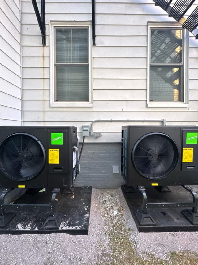 Two Jetson Air heat pump condensers installed side by side against the exterior wall of a home in Attleboro, MA.