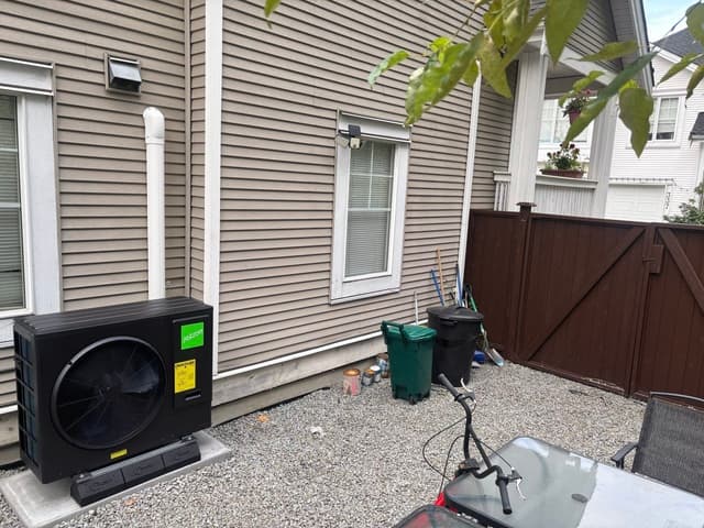 Black Jetson Air 3-ton central ducted heat pump condenser installed along the side of a beige house in Ranch Park, Coquitlam.