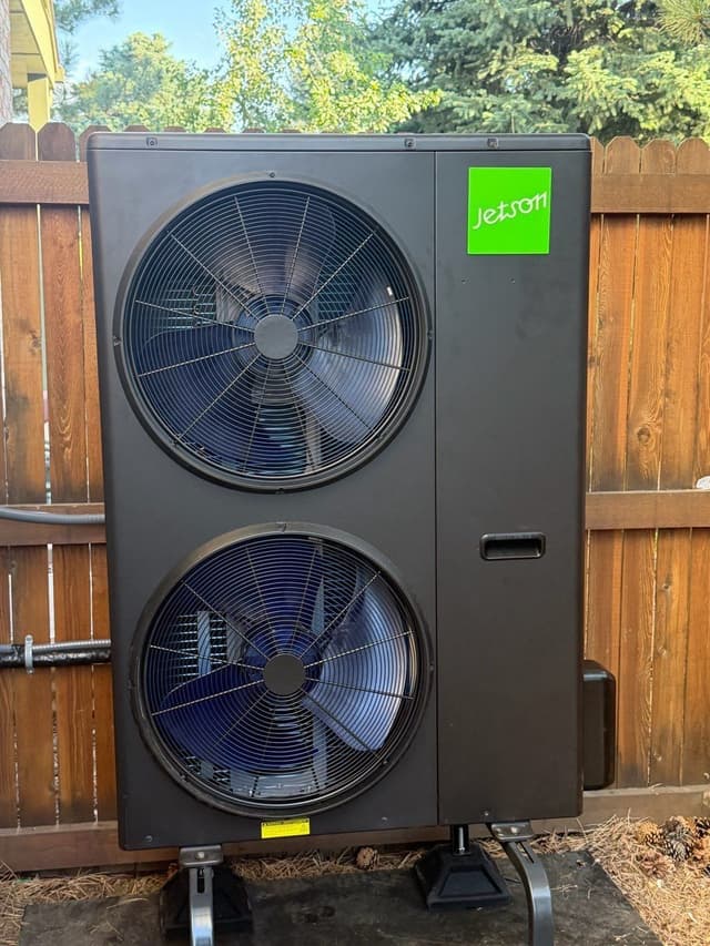 Jetson Air 4-ton central ducted heat pump mounted on a concrete pad in front of a cedar privacy fence in Englewood, CO.