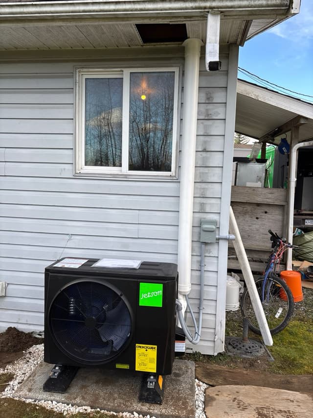Jetson Air 2-ton ducted heat pump on a concrete pad against grey vinyl siding at a residential home in Langley Township, BC.
