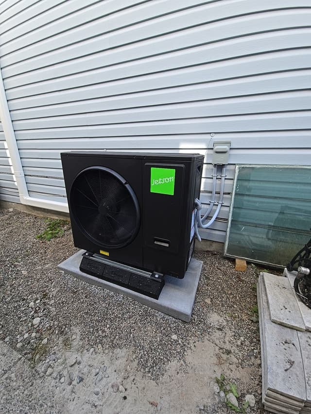 Jetson Air 3-ton heat pump condenser installed against white vinyl siding at a Lincoln Park home in Port Coquitlam, BC.
