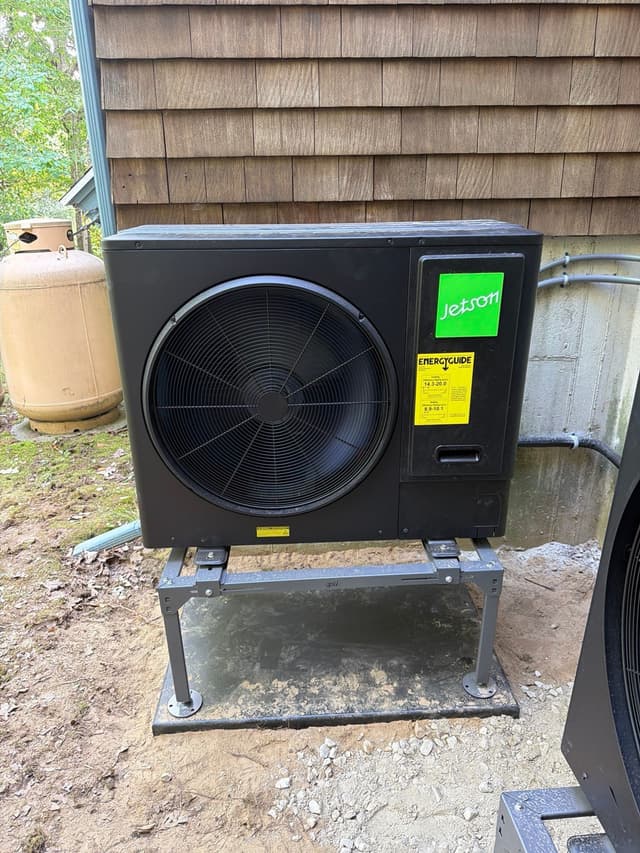 Jetson Air 3-ton central ducted heat pump installed beside a cedar-shingle home in Cordaville, Southborough, MA, with a propane tank visible in the background.