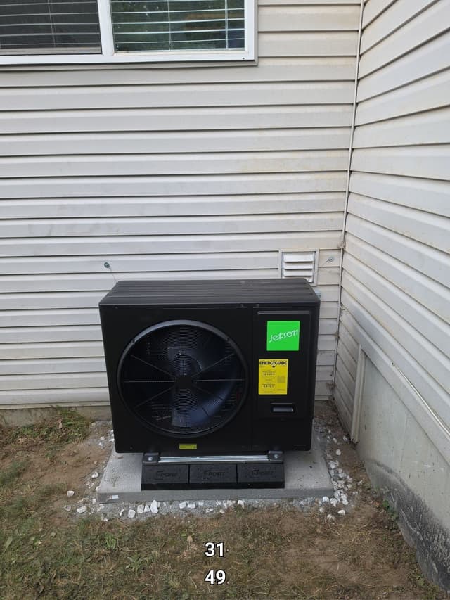 Jetson Air 3-ton central ducted heat pump installed in a house corner on a gravel-surround concrete pad in Fraser Heights, Surrey, BC.