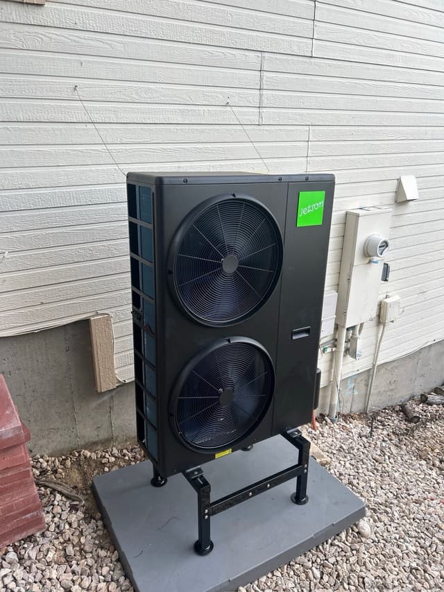 4-ton Jetson Air dual-fan heat pump condenser installed against white lap siding at a home in Westminster, with utility meter and electrical disconnect visible on the wall.