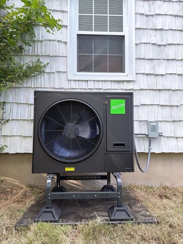 Jetson Air 3-ton central ducted heat pump installed against gray cedar-shingle siding of a home in White Plains, NY.