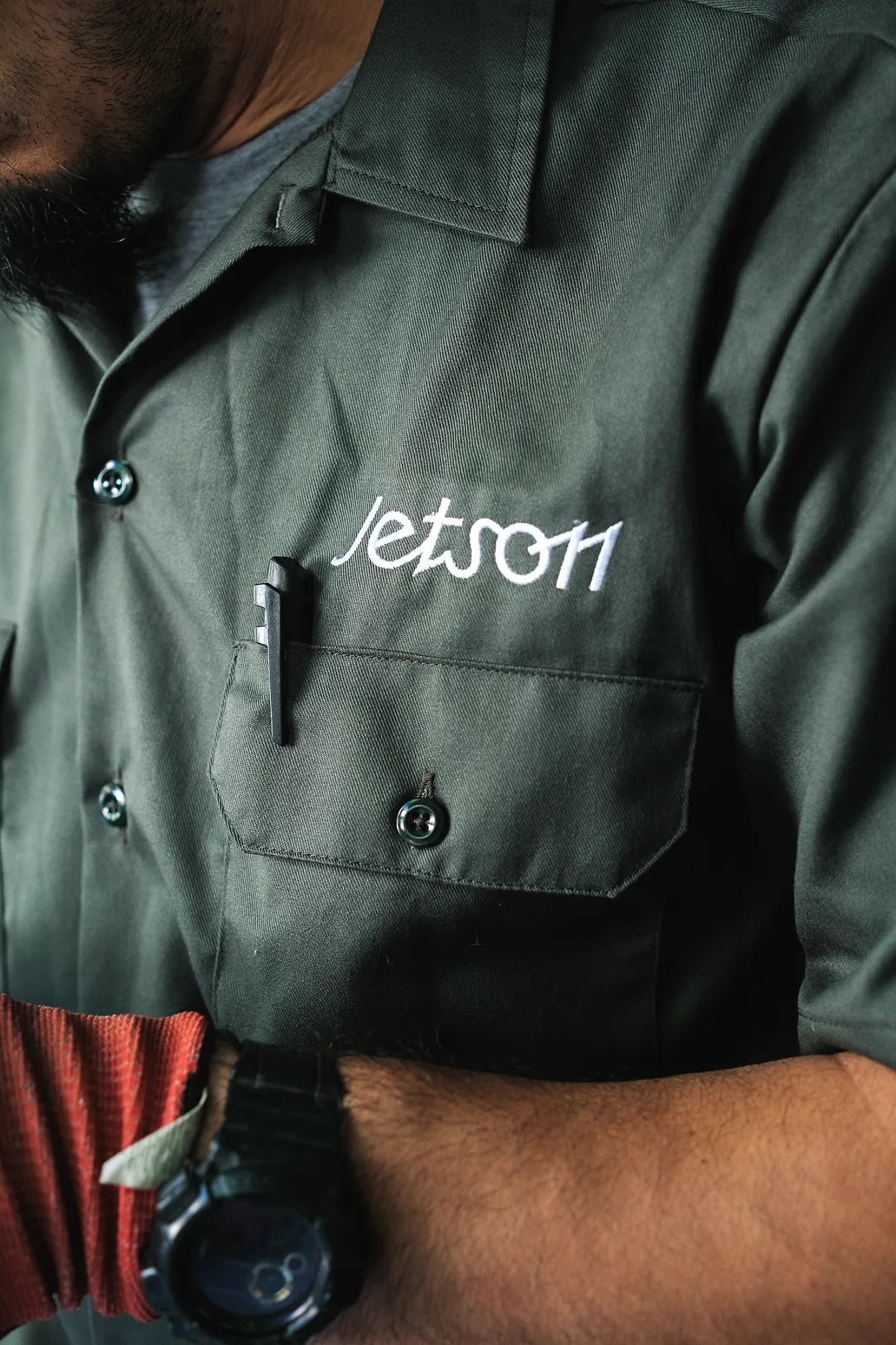Close-up of a Jetson technician's green work shirt with the Jetson logo