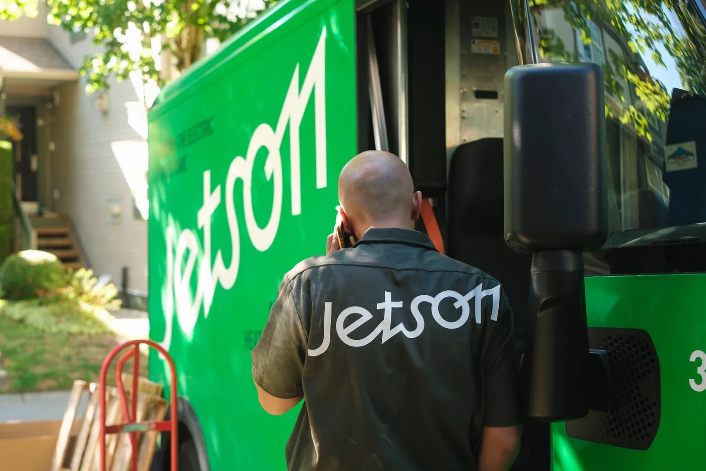 A Jetson technician beside a green Jetson install van