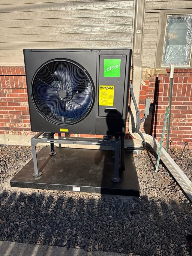 3-ton Jetson Air central ducted heat pump installed along the side of a brick house in Arvada, Colorado, with line-set conduit and EnergyGuide label visible.