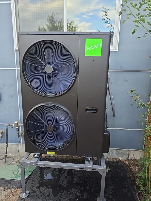 Jetson Air 4-ton central ducted heat pump installed against the side of a light-blue home in Boulder, Colorado.