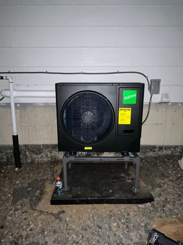 3-ton central ducted heat pump installed on the exterior of a concrete block wall at a home in Brighton, CO.