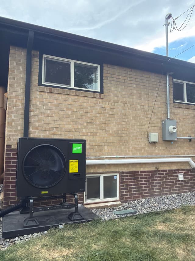 Jetson Air 3-ton central ducted heat pump installed beside a brick home in Denver, with line sets and conduit running neatly along the foundation and a disconnect box mounted on the wall.