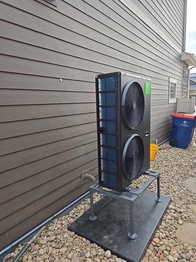 4-ton Jetson Air central ducted heat pump installed along the side of a gray lap siding home in Erie, CO, with refrigerant lines visible at the base.