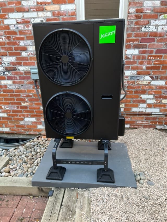 A 4-ton Jetson Air central ducted heat pump installed against a red brick exterior wall in Fort Collins, Colorado.