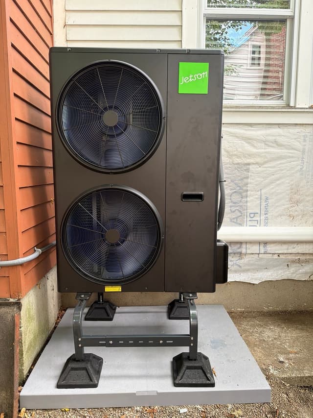 4-ton Jetson Air dual-fan heat pump installed on the side of a house in Framingham, MA, with conduit running along the siding.