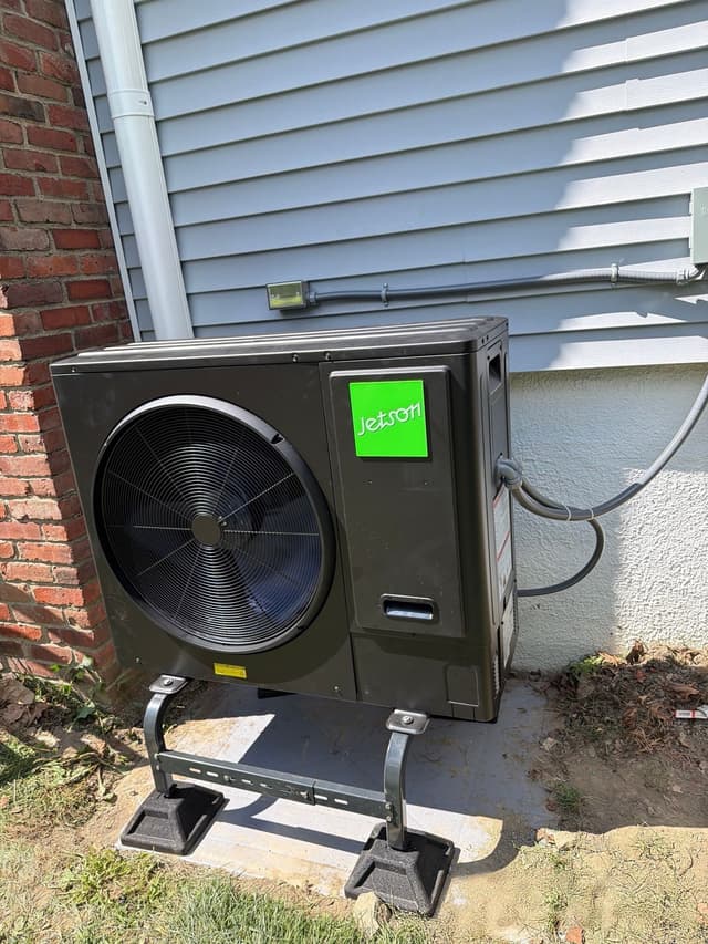 Jetson Air 3-ton central ducted heat pump condenser installed against gray vinyl siding with brick corner on a Marblehead home.