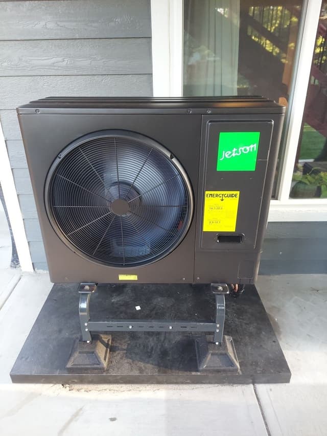 Jetson Air 3-ton central ducted heat pump installed on a concrete patio beside gray lap siding and a sliding glass door at a home in Parker, CO.