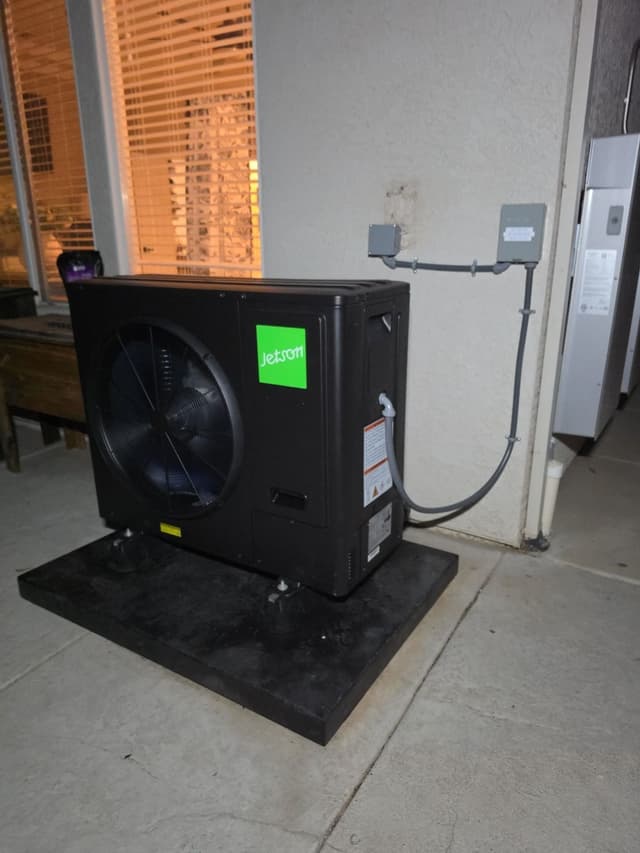 3-ton central ducted heat pump installed on a concrete patio against a stucco exterior wall in Roseville, with gray conduit running to electrical disconnect boxes mounted on the wall.