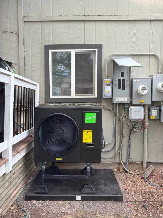 Jetson Air 3-ton central ducted heat pump condenser installed against the exterior of a Westminster home, with electrical panel, disconnect box, and utility meter visible alongside.
