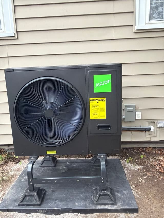Jetson Air 3-ton central ducted heat pump installed on an anti-vibration pad against beige vinyl siding at a home in Weymouth, MA.